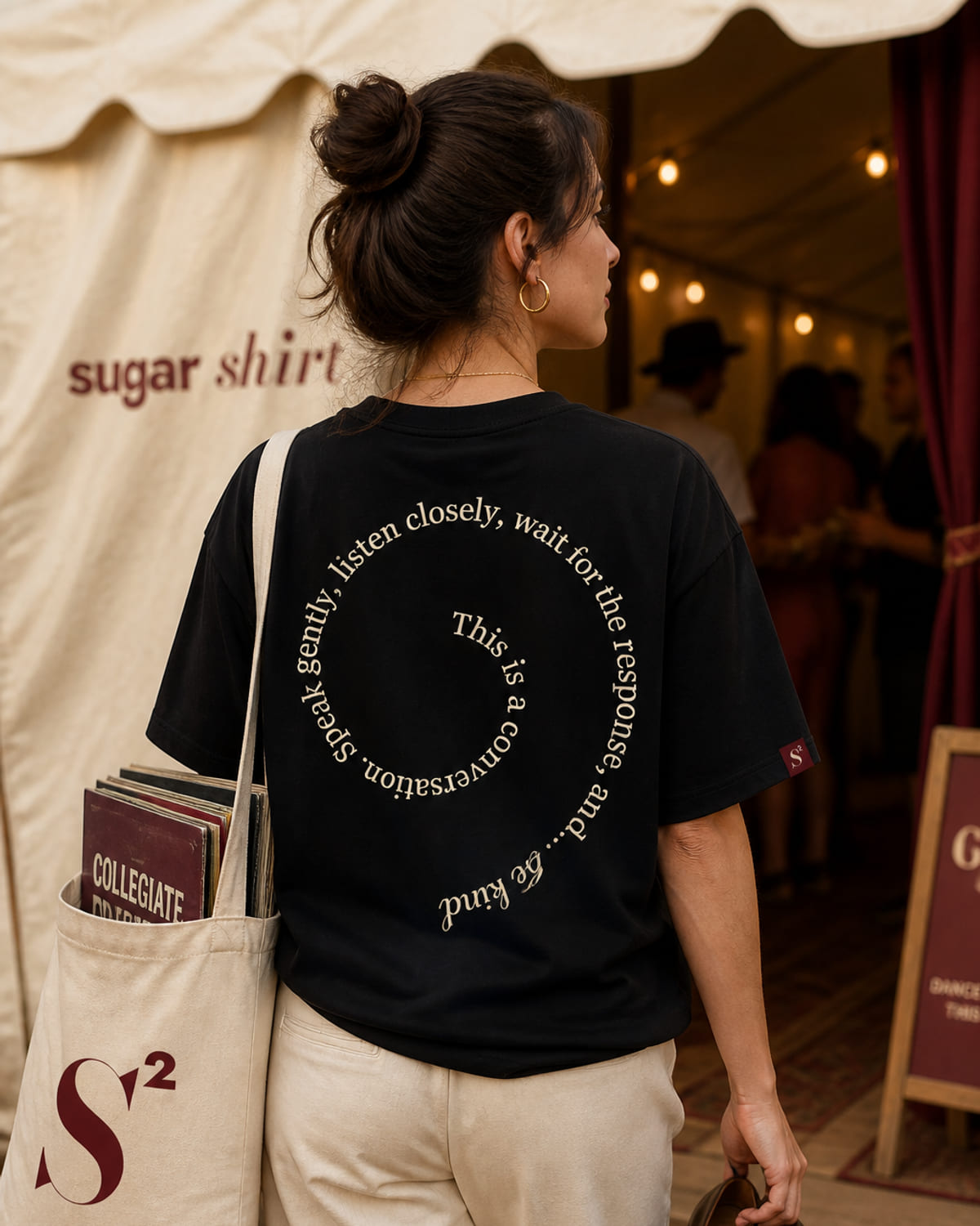 T-shirt oversize nero con una frase disposta in spirale sul petto e sulla schiena