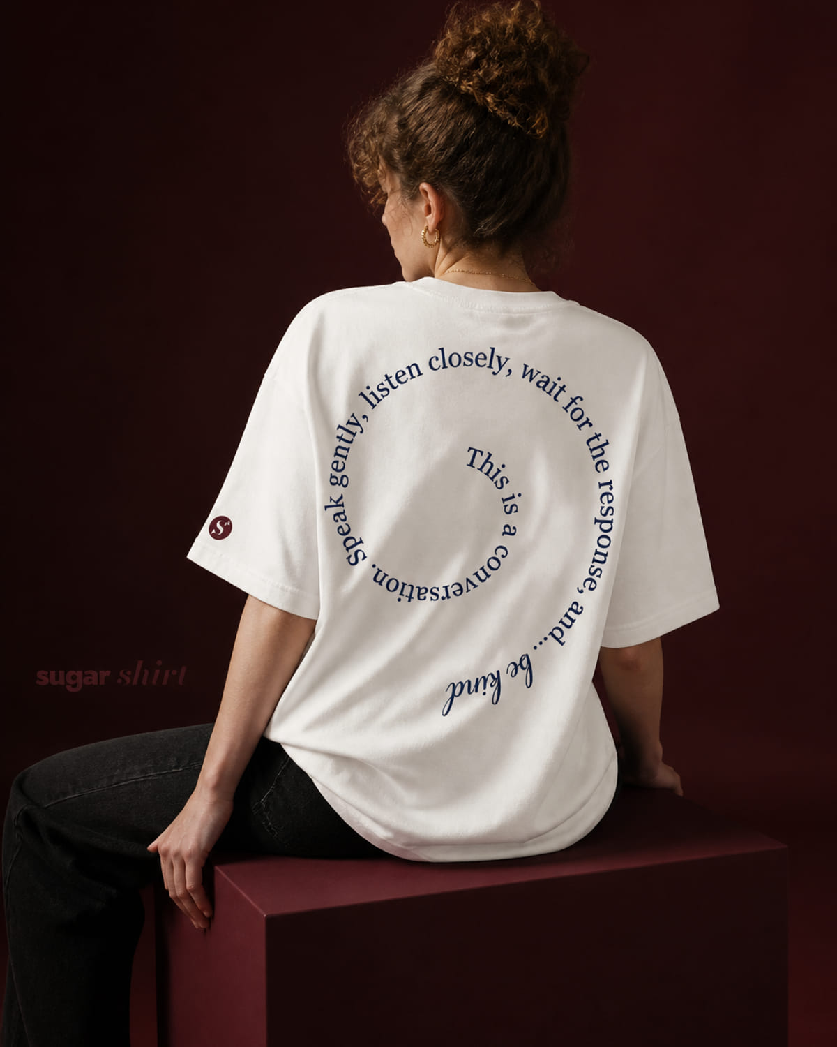 T-shirt oversize crema con una frase disposta in spirale sul petto e sulla schiena